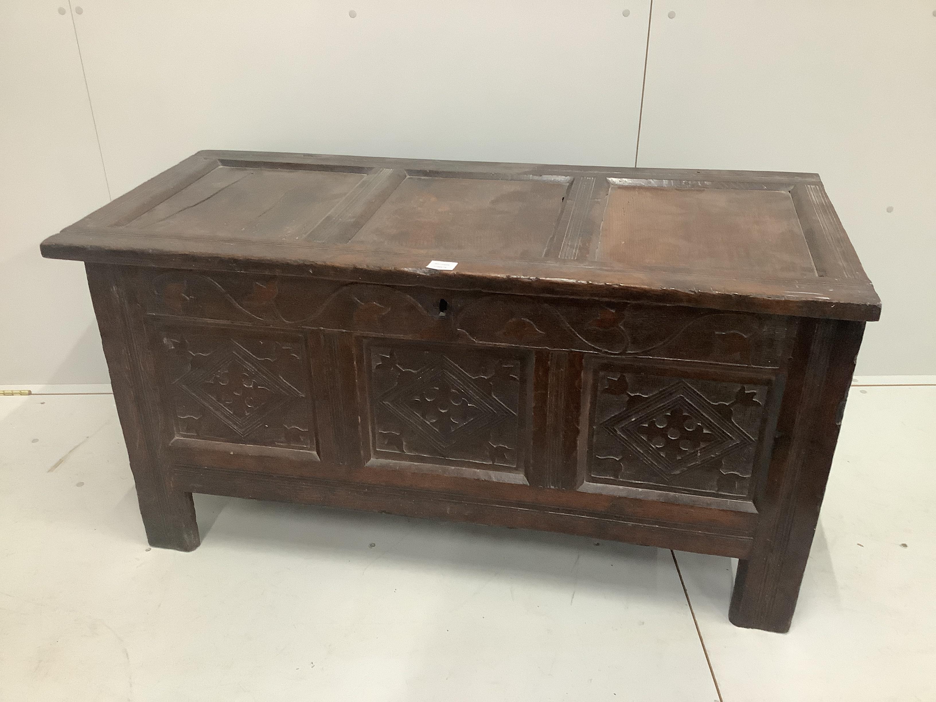 A 17th century and later panelled oak coffer with shallow carved foliate details, width 126cm